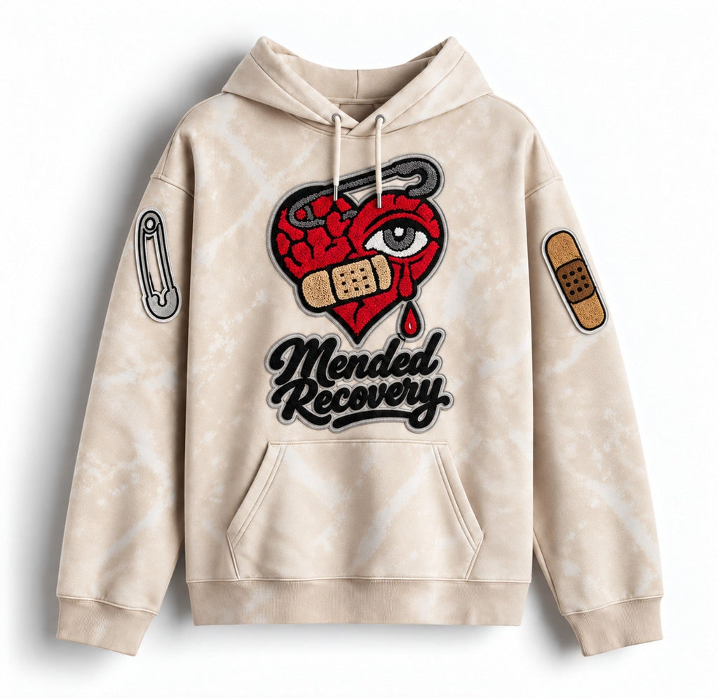 Cream distressed Mended Recovery hoodie – sleeve patch statement layout